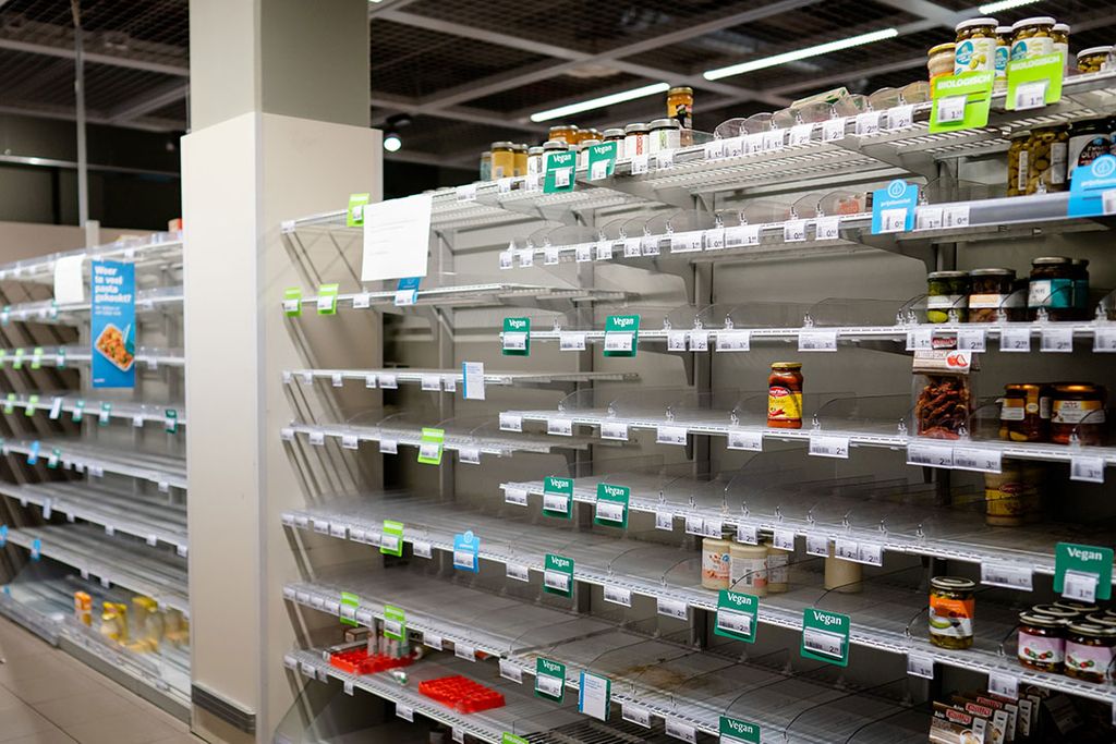 Lege schappen in een supermarkt door het hamsteren vanwege het coronavirus. - Foto: ANP
