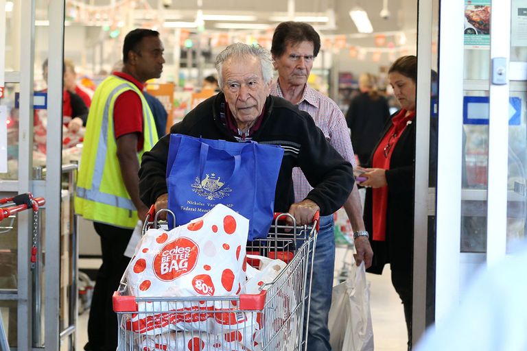 Een klant verlaat de Australische supermark Coles met een kar vol boodschappen. - Foto: ANP
