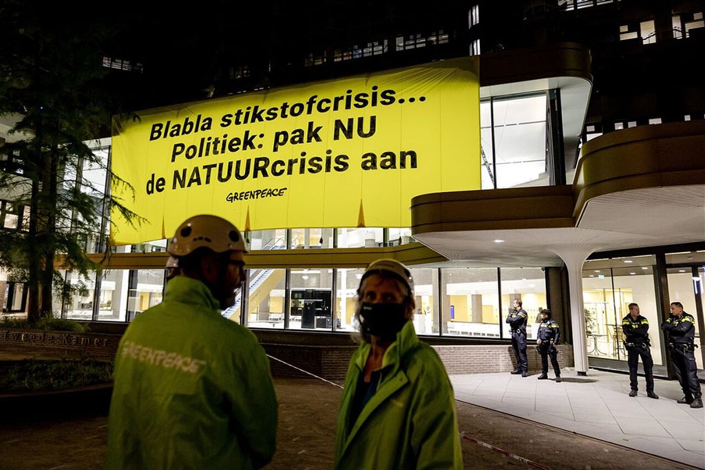 Activisten van Greenpeace hebben het tijdelijke gebouw van de Tweede Kamer in Den Haag beklommen. Ze vragen met hun actie aandacht voor de stikstofproblematiek. - Foto: ANP