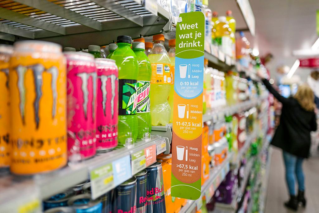 Flesjes en blikjes in een supermarktschap. Op alle flesjes kleiner dan 1 liter wordt vanaf 1 juli 15 cent extra geheven, vanaf 31 december 2022 komt ook statiegeld op blikjes. Foto: ANP