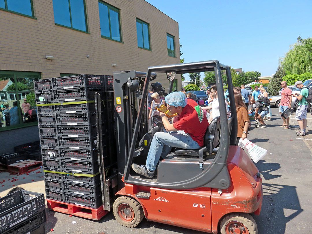 Een heftruck voert tomaatjes aan bij een weggeefactie. - Foto: Ton van der Scheer