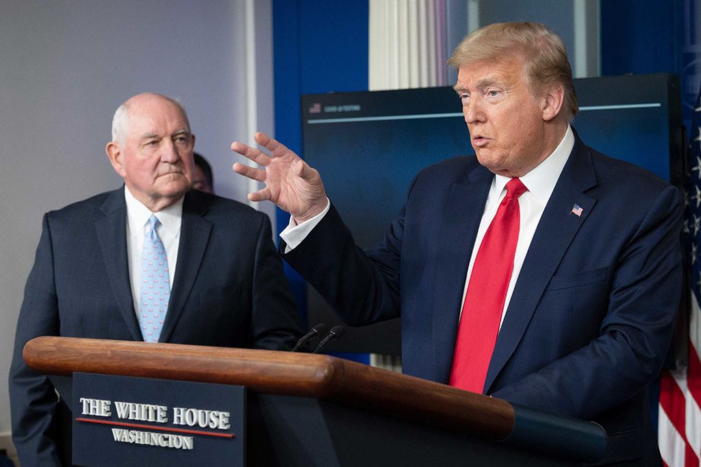 De Amerikaanse president Donald Trump licht de steunmaatregelen voor boeren toe met naast hem landbouwminister Sonny Perdue. - Foto: ANP