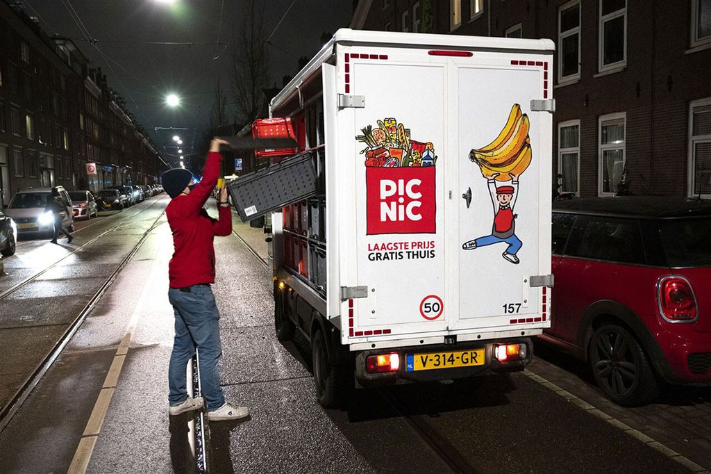 Een Picnic-bezorger levert boodschappen af bij een klant. Bezorgers van maaltijden en boodschappen zijn niet meer weg te denken uit het straatbeeld. Foto: ANP / Evert Elzinga