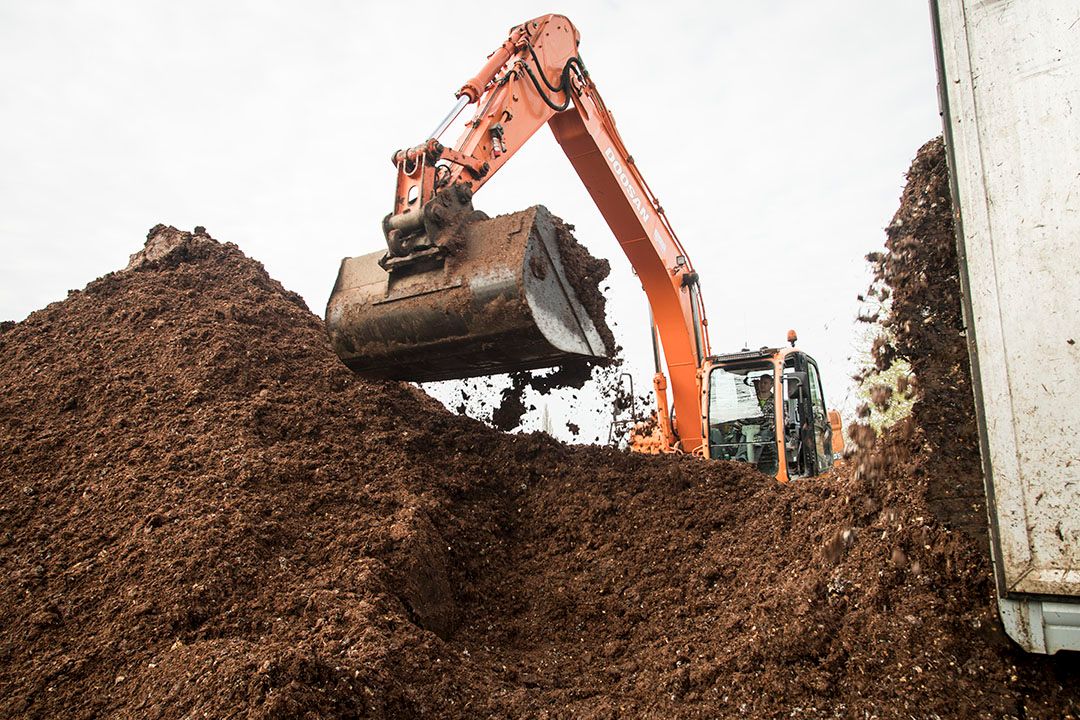 Lossen van compost. Een deel van de in Nederland geleverde compost voldoet ondanks certificering niet aan de voedselveiligheids eisen. - Foto: Koos Groenewold