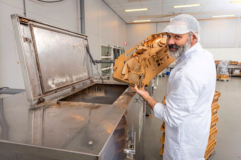 Sebastiaan Hetterschijt van Bakkersgrondstof vult de broodmeelmachine met oud brood. "Nieuw deeg kan voor 25% uit oud brood bestaan." - Foto: Koos Groenewold