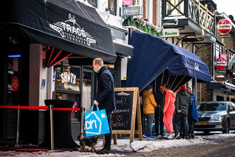 Feestvierders halen een carnavalspakket op bij een café in Eindhoven. De eerste helft van dit jaar zal voor horecaleveranciers nog weinig perspectief bieden. - Foto: ANP/HH/Rob Engelaar