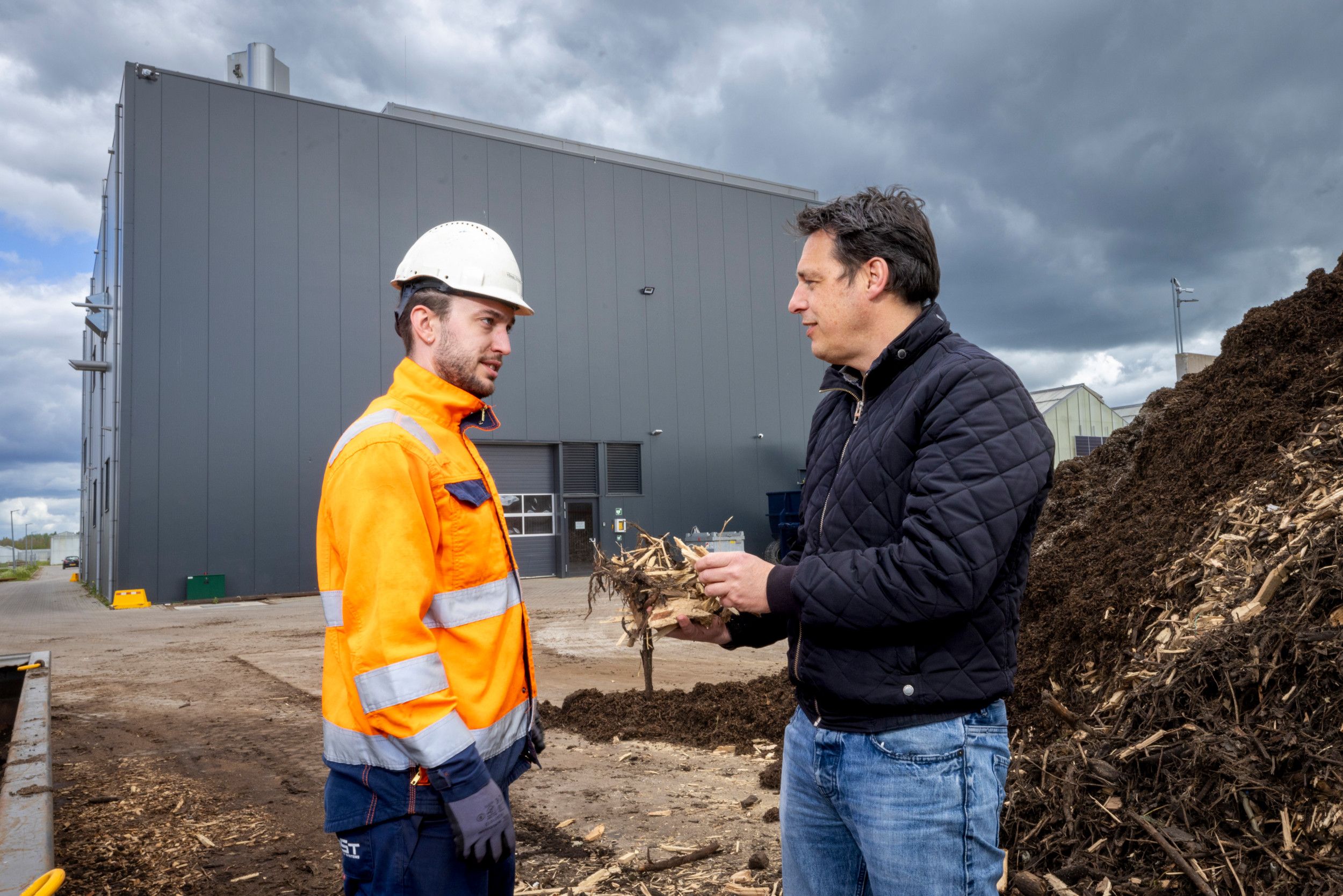 Berno Schouten, directeur Lingezegen Energy (r),  overlegt met een operator van de biomassacentrale van het bedrijf HOST. Foto: Koos Groenewold