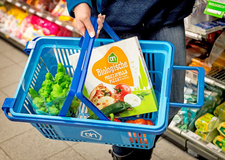 Biologische pizza in een winkelmandje. Biologische grondstoffen zijn vaak duurder dan gangbare. Foto: ANP