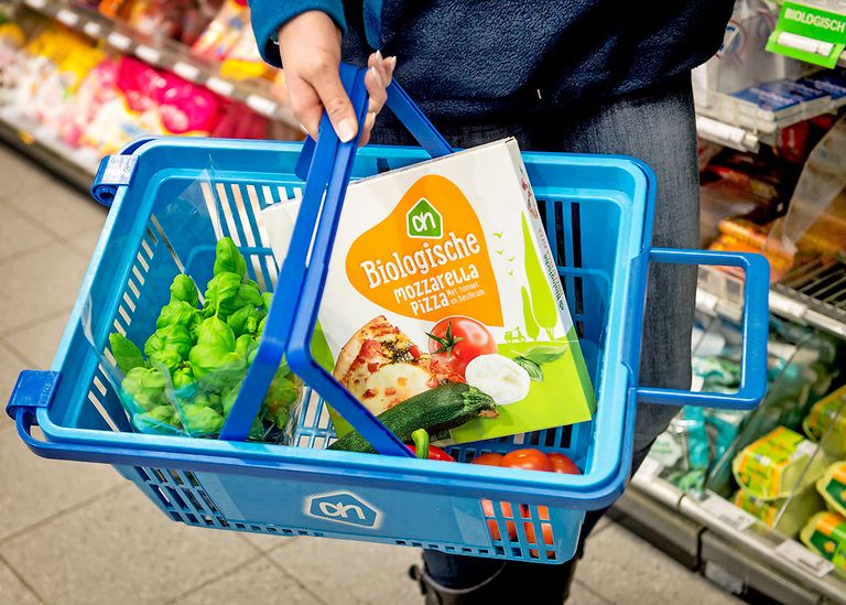 Biologische pizza in een winkelmandje. Biologische grondstoffen zijn vaak duurder dan gangbare. Foto: ANP