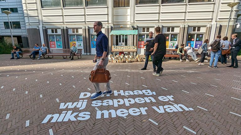 Passanten lopen voorbij protestactie van de sapmakers.