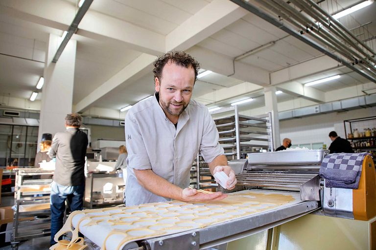 Bakker Edwin Klaasen steekt zijn gevulde koeken uit de bakplaat. Toen door corona de inkomsten wegvielen van het bakkersbedrijf - dat brood levert aan de horeca - gooide hij het over een andere boeg. - Foto: Herbert Wiggerman