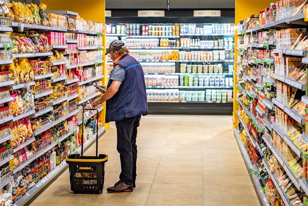 Een consument in een supermarkt. De volumegroei in de supermarkten is dit jaar groot. - Foto: ANP