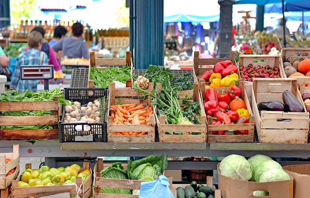 De marktkraam van een groenteboer. De markt is bij uitstek een plek waar consumenten lokaal geproduceerd voedsel kopen. - Foto: Canva/Baloncici