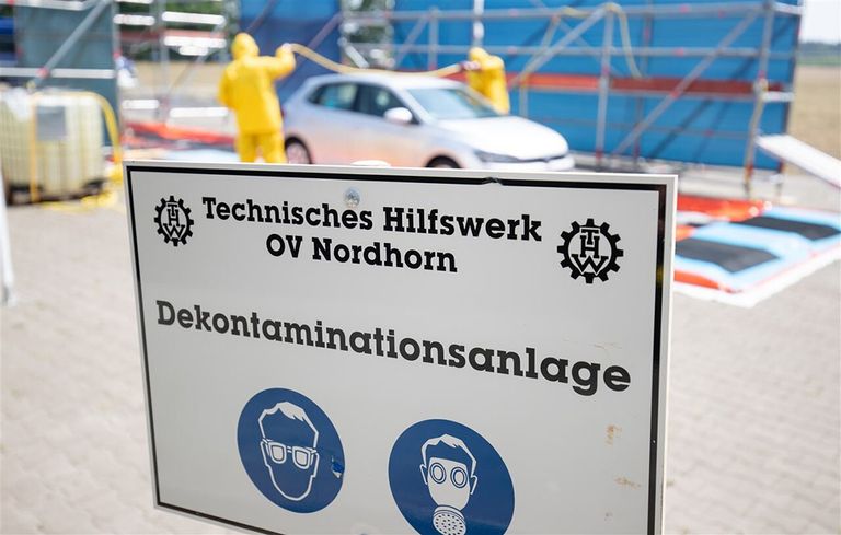 Een auto wordt gedesinfecteerd nadat deze op een varkensboerderij is geweest in het Duitse district Emsland. - Foto: ANP