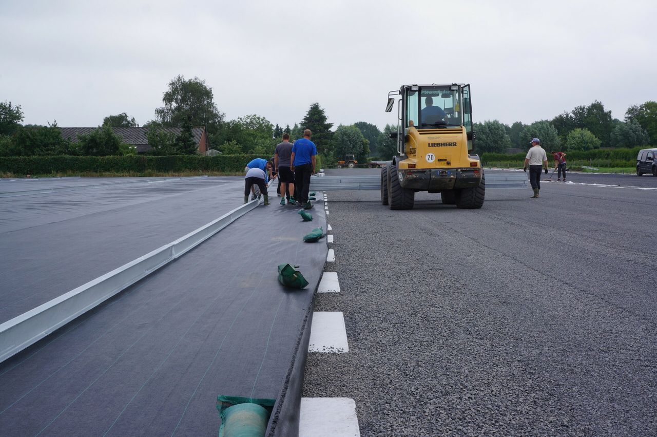 De aanleg van het trayveld: het uitleggen van de rails voor de over-gewaswagen.