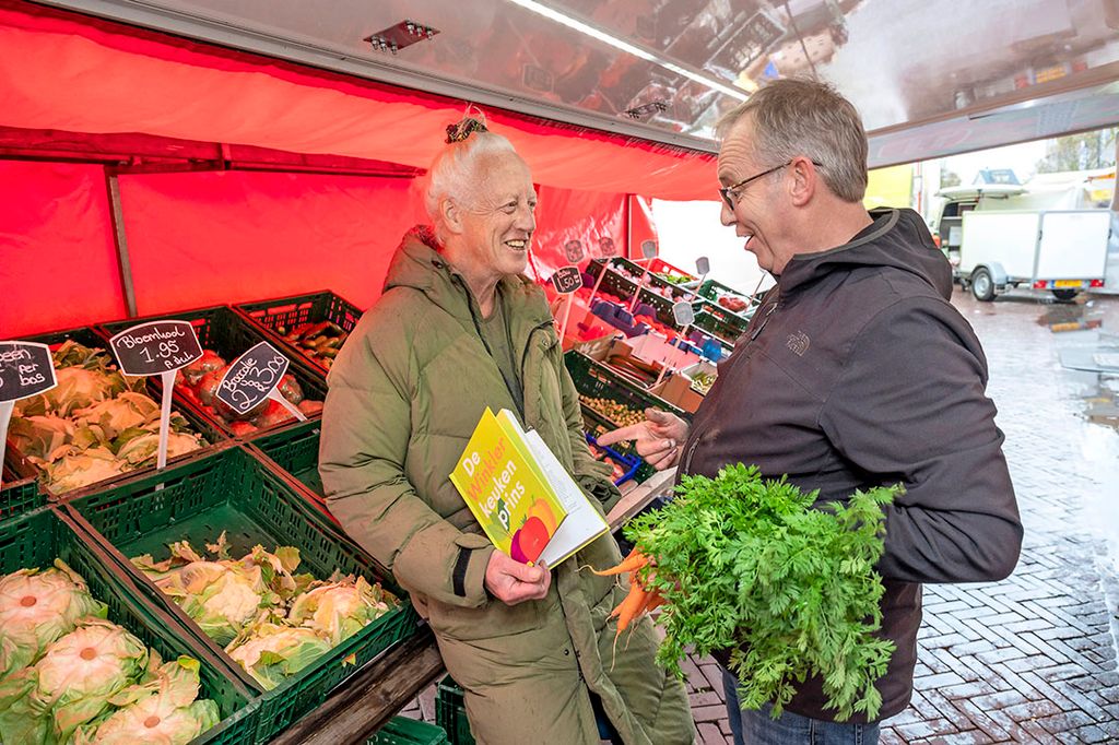 Kookschrijver Pierre Winkler bij een van zijn vaste groenteleveranciers op de weekmarkt in Zandvoort. - Foto: Cor Salverius Fotografie