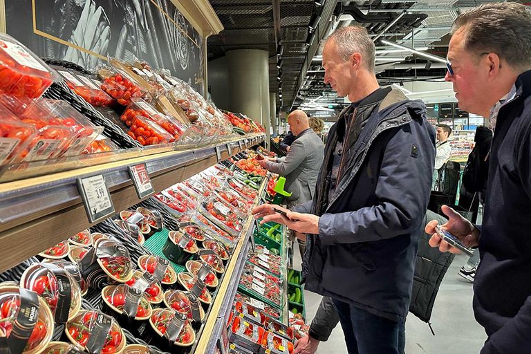 Wilco van den Berg en tomatenteler Jos van Mil bestuderen het tomatenaabod in een Edeka supermarkt  in Düsseldorf. - Foto: Wilma van den Oever