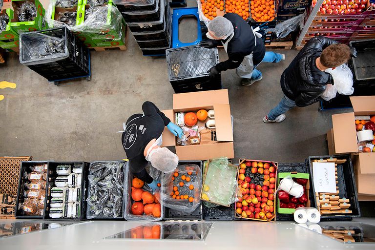 Medewerkers van Support Your Locals pakken voedselboxen in met producten die vanwege de coronacrisis niet meer afgezet kunnen worden aan de horeca. - Foto: Olaf Kraak/ANP