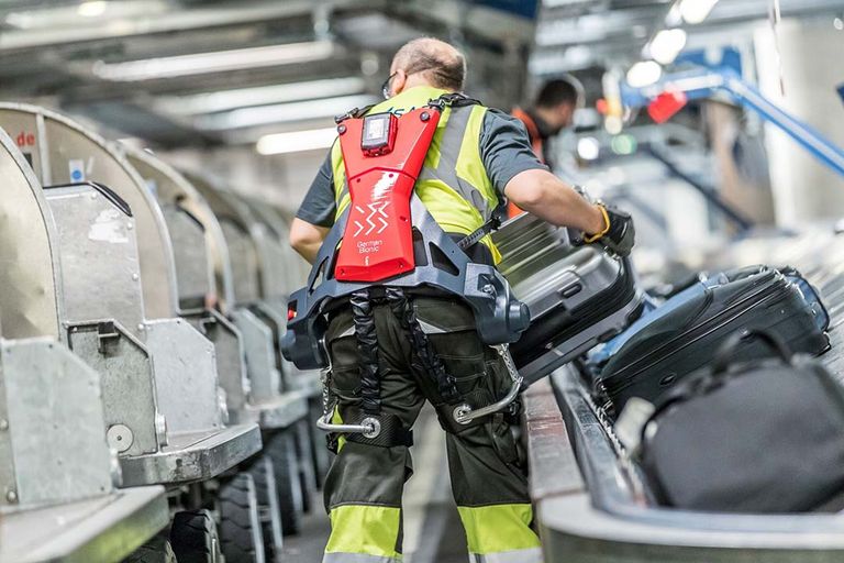 Mechanisch ondersteund door een zogeheten exoskelet tilt Duits bagagepersoneel in Stuttgart met minder risico op blessures. - Foto: Germna Bionic