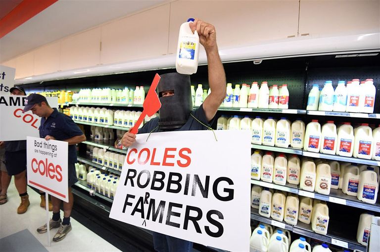 Australische melkveehouders protesteren in een supermarkt van Coles, waar melk van het huismerk voor 1 Australische dollar verkocht wordt. - Foto: ANP