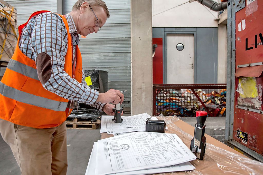 Een NVWA-medewerker stempelt het papierwerk bij een controle. Een groter deel van de tariefstijgingen gaat worden gecompenseerd. - Foto: Diederik van der Laan