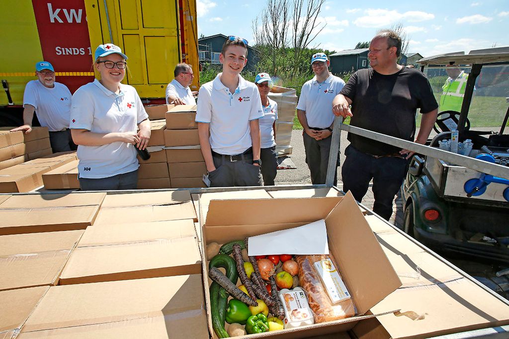 Medewerkers van het Rode Kruis en rechts Bart Plaatje van FNV klaar voor het rondbrengen van de boxen bij arbeidsmigranten in Zeewolde. - Foto: Ton Kastermans