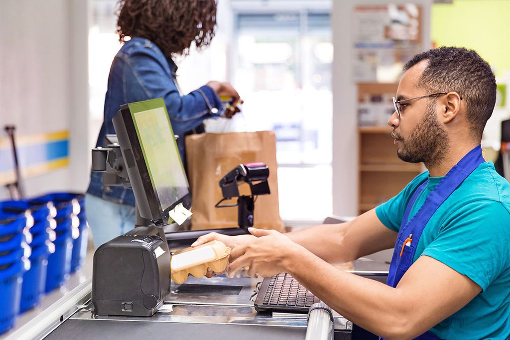 Een klant staat bij de kassa van een supermarkt. Voedingsprijzen zijn hoog, en blijven dat langer dan in eerdere periodes met hoge prijzen. - Foto: Canva/MangoStar_Studio